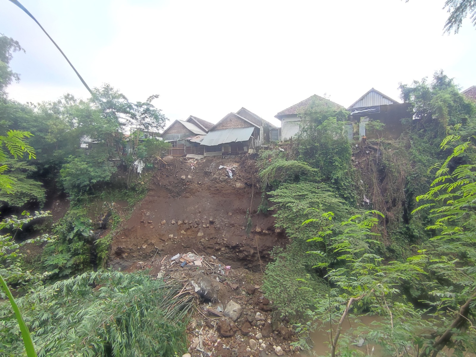 TERDAMPAK: Tebing bibir Sungai Pikatan di Dusun/Desa Pohjejer, Kecamatan Gondang alami longsor dan mengancam bangunan rumah warga.