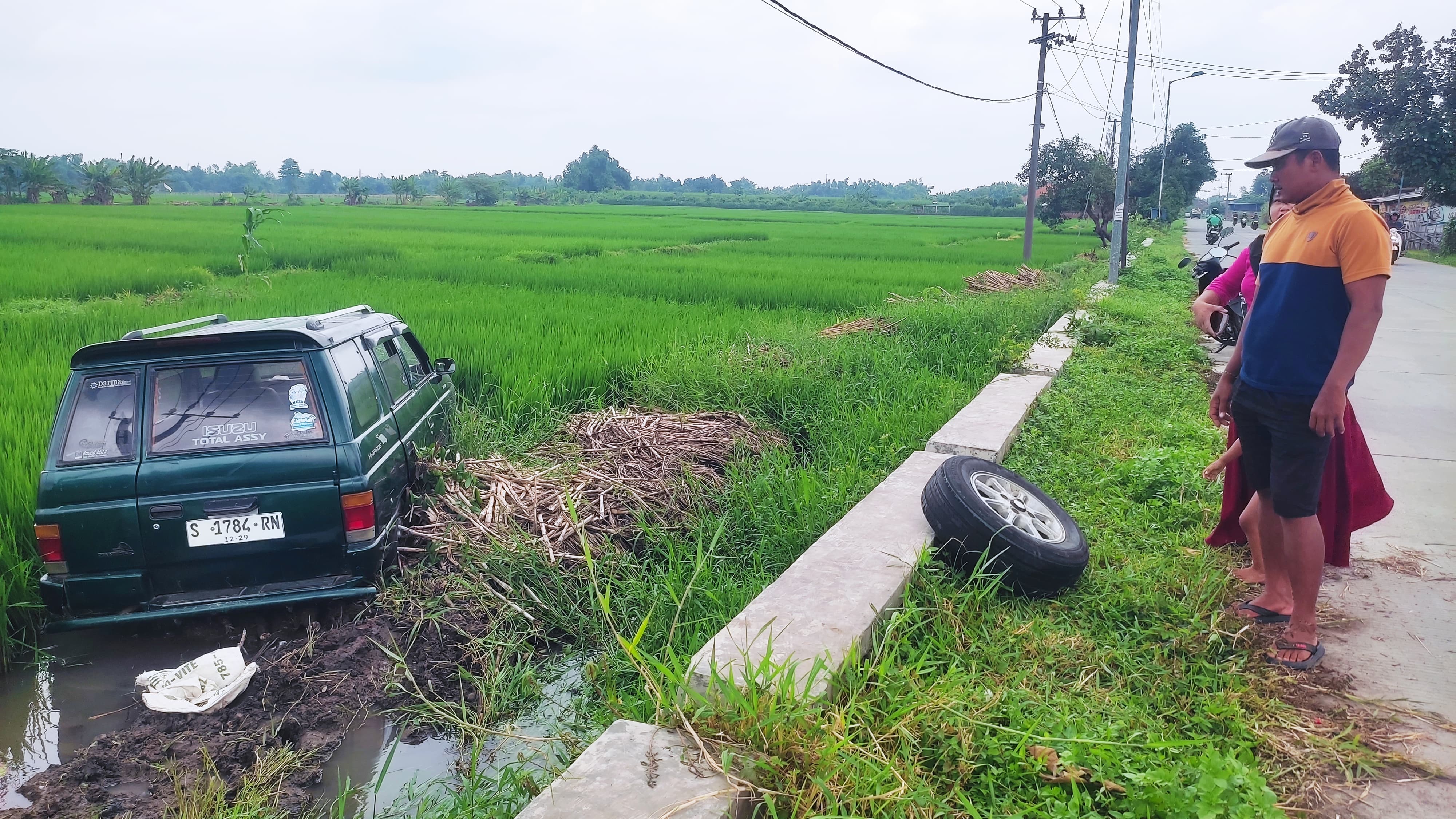 KELUAR JALUR: Mobil Isuzu Panther nyungsep di persawahan saat melintas di Jalan Raya Desa Medali, Kecamatan Puri, Senin (3/2).