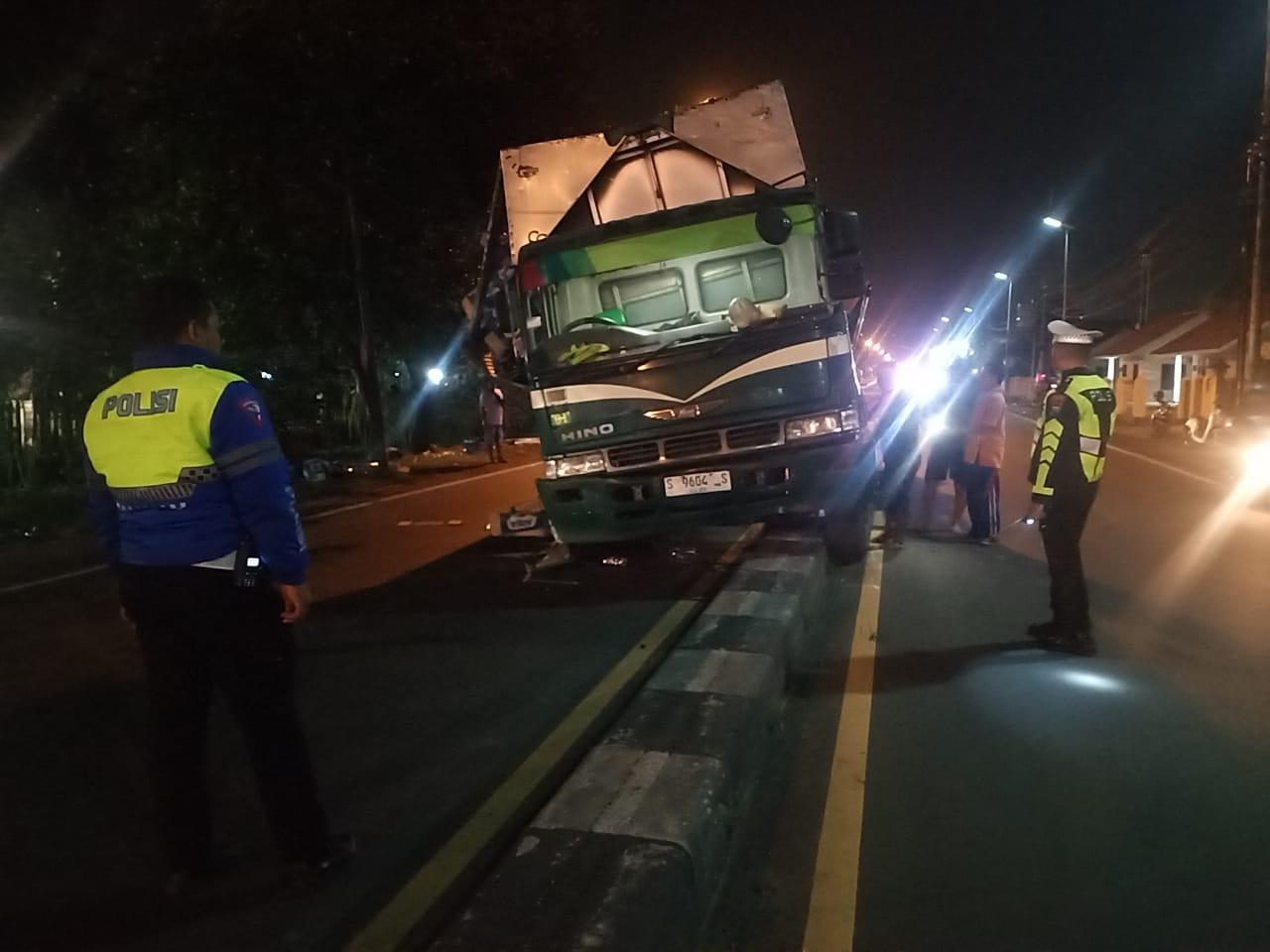 TERSANGKUT: Truk wing boks nopol S 9604 S menghantam median jalan di depan SPN Polda Jatim Bangsal, Selasa (4/2).