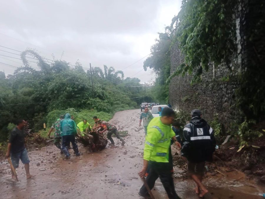 MENUTUP JALAN: Petugas gabungan mengevakuasi material longsor yang menutup Jalan Desa Cepokolimo, Kecamatan Pacet, Kamis (6/2).