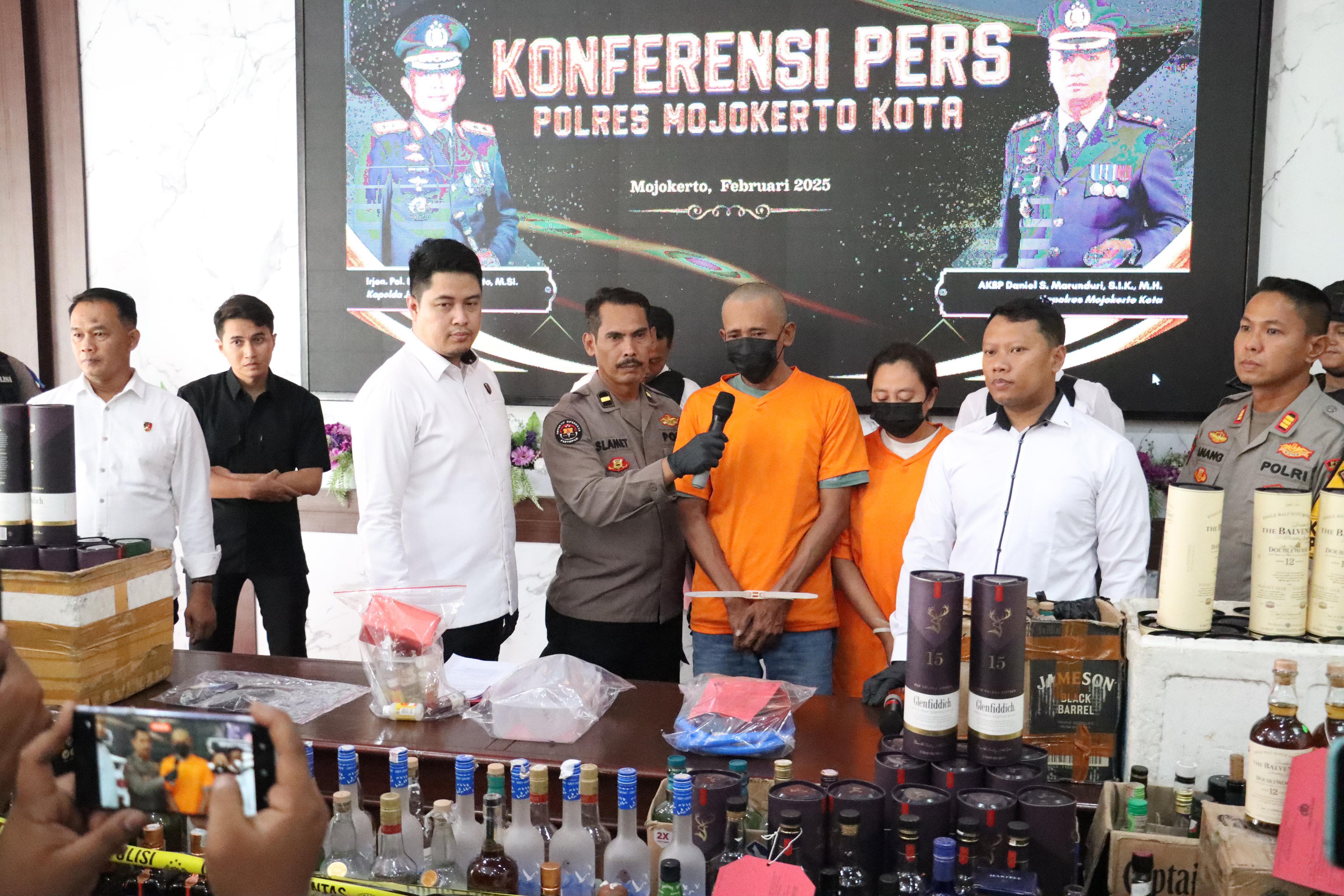 PERACIK MIRAS: Polisi menginterogasi pasutri pemilik rumah produksi miras oplosan saat rilis kasus, Senin (10/2).