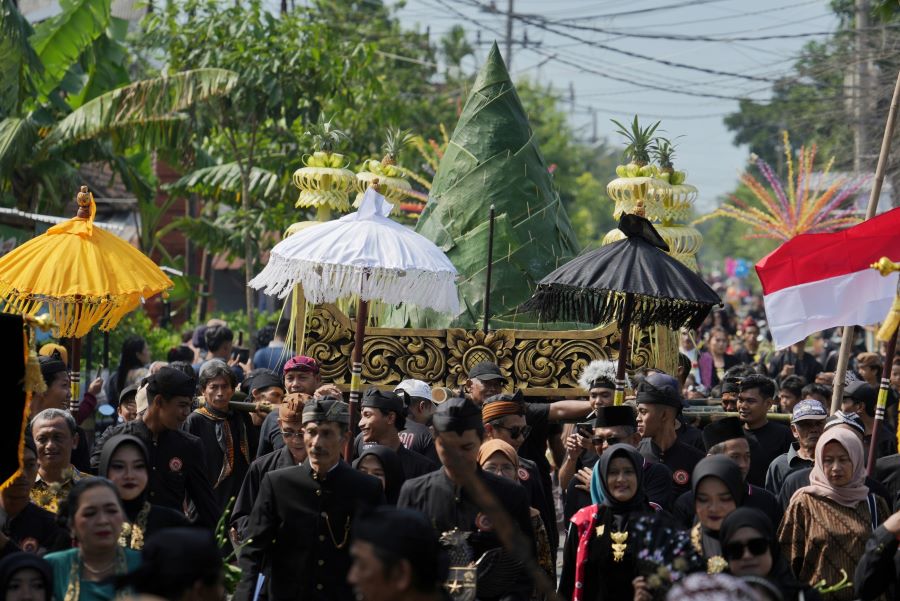 WUJUD SYUKUR: Ratusan warga Kelurahan Blooto, Kota Mojokerto membuka tudung tumpeng agung usai diarak keliling kampung dan didoakan di kompleks pemakaman leluhur setempat, kemarin