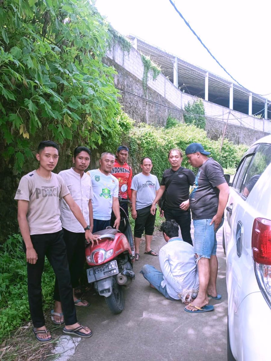 TAK BERKUTIK: Pelaku (meringkuk di bawah) hanya bisa pasrah saat diamankan petugas dan warga setelah tepergok melintas di wilayah Kecamatan Pungging.