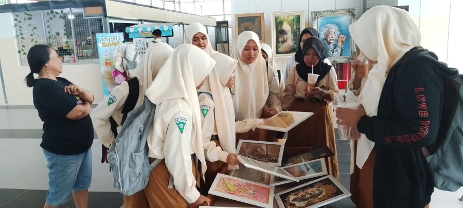 PENASARAN: Sejumlah siswa SMAN 2 Mojokerto menilik pameran sekaligus OTS dari komunitas SAL dalam Festival Seni di Pasar Semeru, Rabu (19/2).