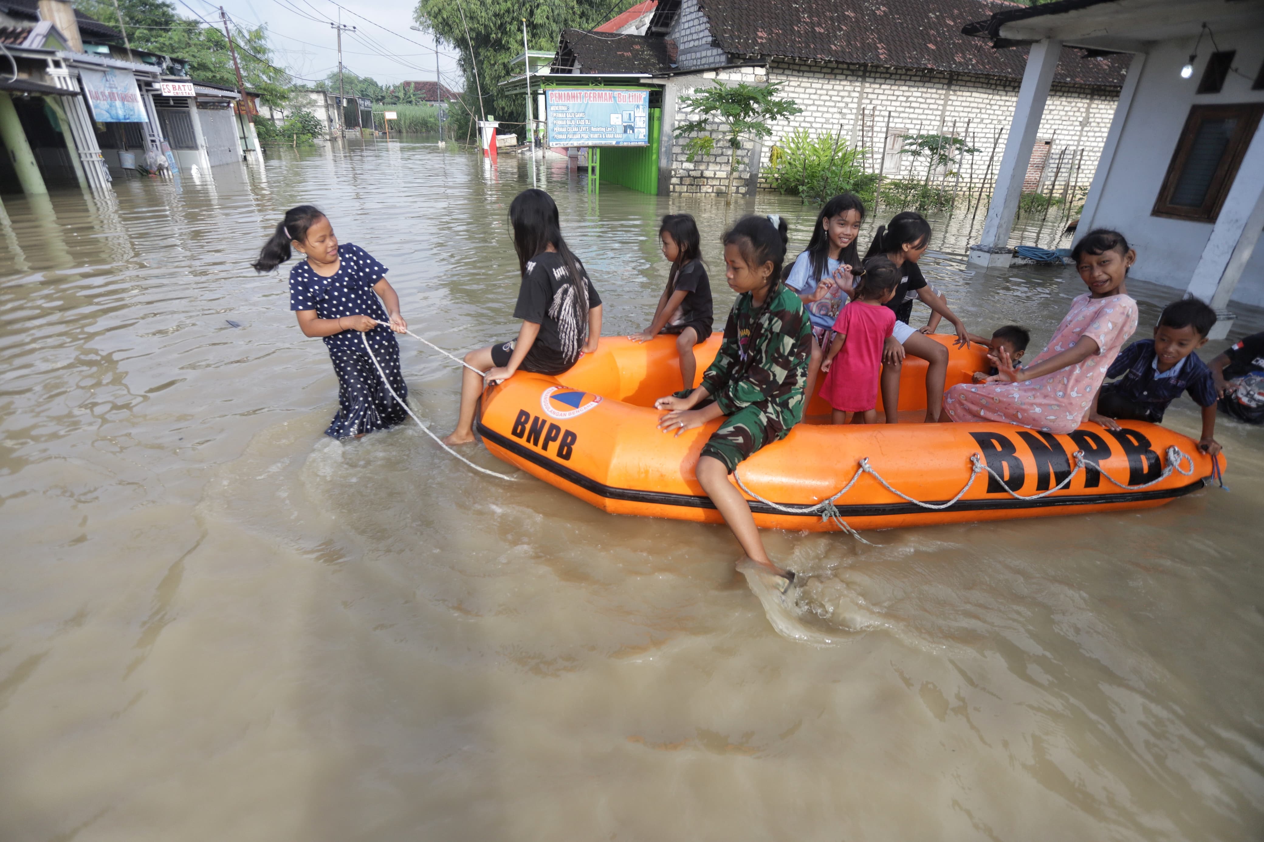 TERENDAM LAGI: Warga Dusun Klanting, Desa Pulorejo, Kecamatan Dawarblandong, Kabupaten Mojokerto melintas banjir dengan perahu kebencanaan, Sabtu (1/3).