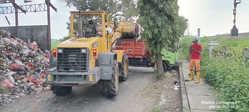 DIBERSIHKAN: Petugas DLH Kota Mojokerto menerjunkan alat berat untuk mengangkut tumpukan sampah dari TPS Blooto menuju ke TPA Randegan.