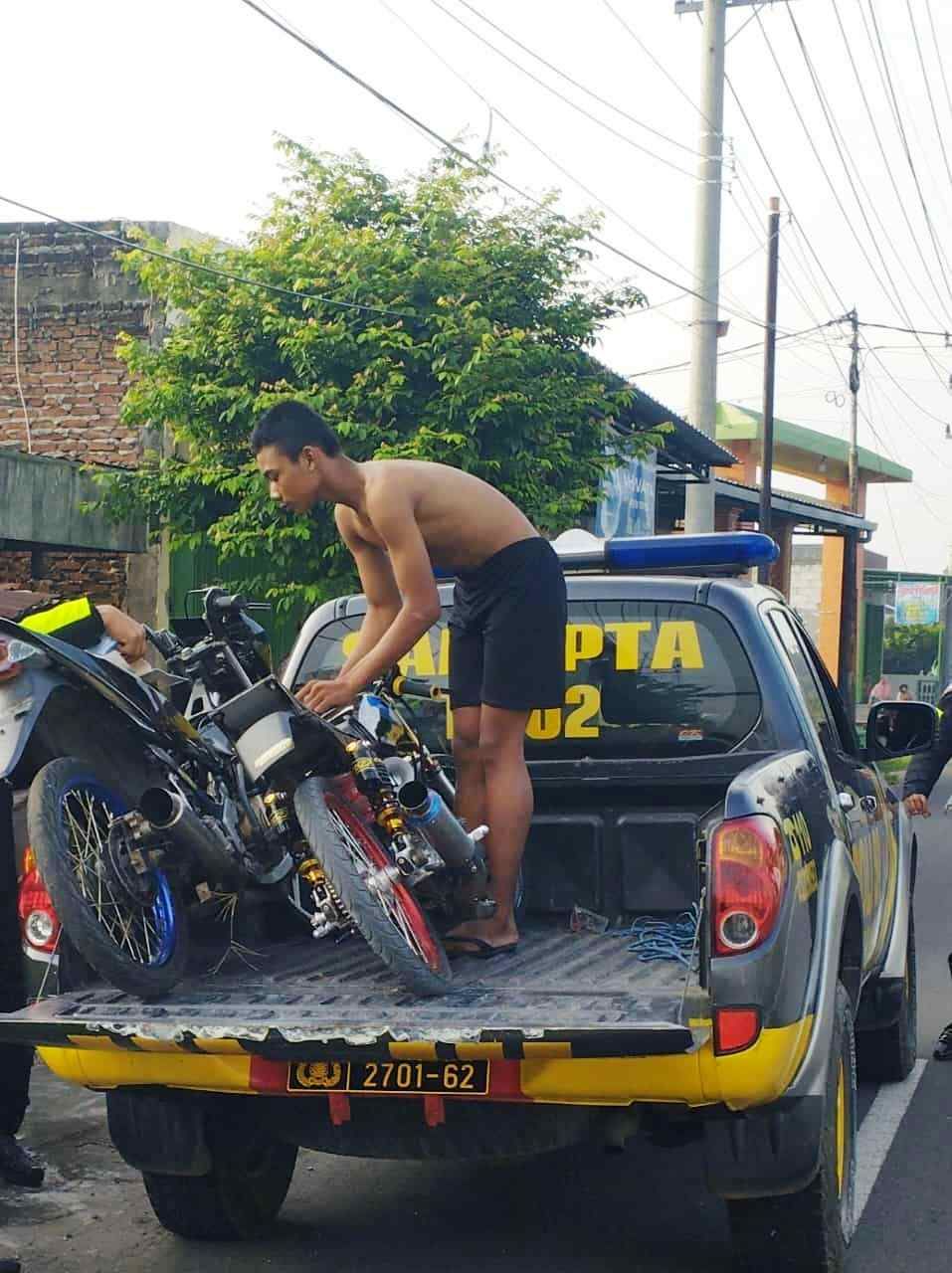 MERESAHKAN: Petugas mengamankan dua pembalap liar saat beraksi di Jalan Raya Pacing-Tumapel, kemarin (5/3) pagi.