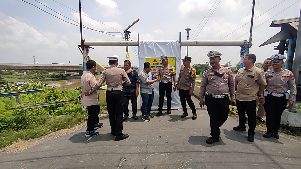 DIBUKA LAGI: General Manager PT SGN Pabrik Gula Gempolkrep Edy Purnomo bersama Kasatlantas Polres Mojokerto Kota AKP Mulyani saat membuka akses jembatan Pagerluyung, di Sungai Brantas, Desa/Kecamatan