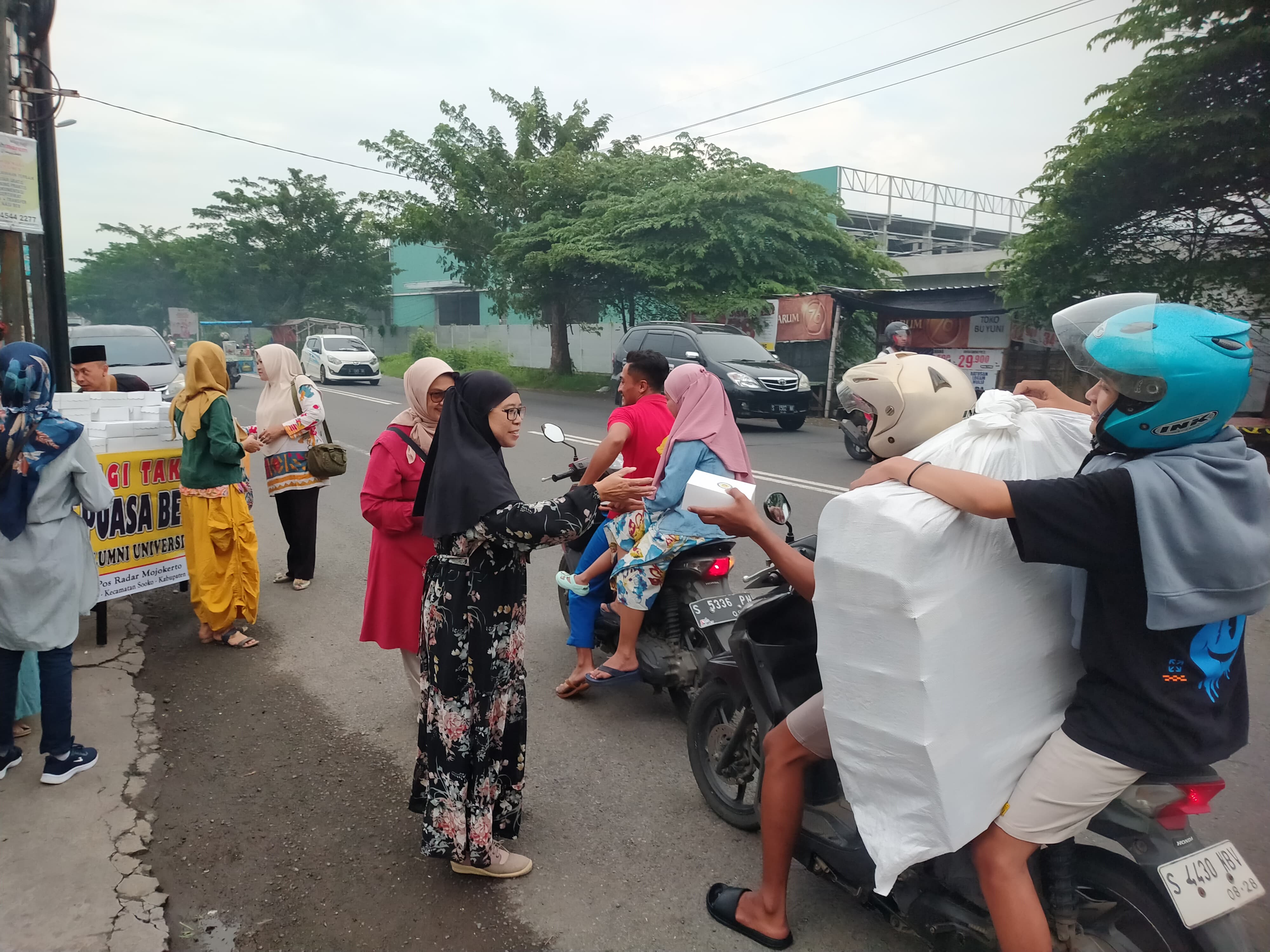 PERERAT SILATURAHMI: Pengurus dan anggota KAUJE Korda Mojokerto Raya membagikan takjil pada pengguna jalan yang melintas di depan Kantor Jawa Pos Radar Mojokerto, Sabtu (8/3) petang.