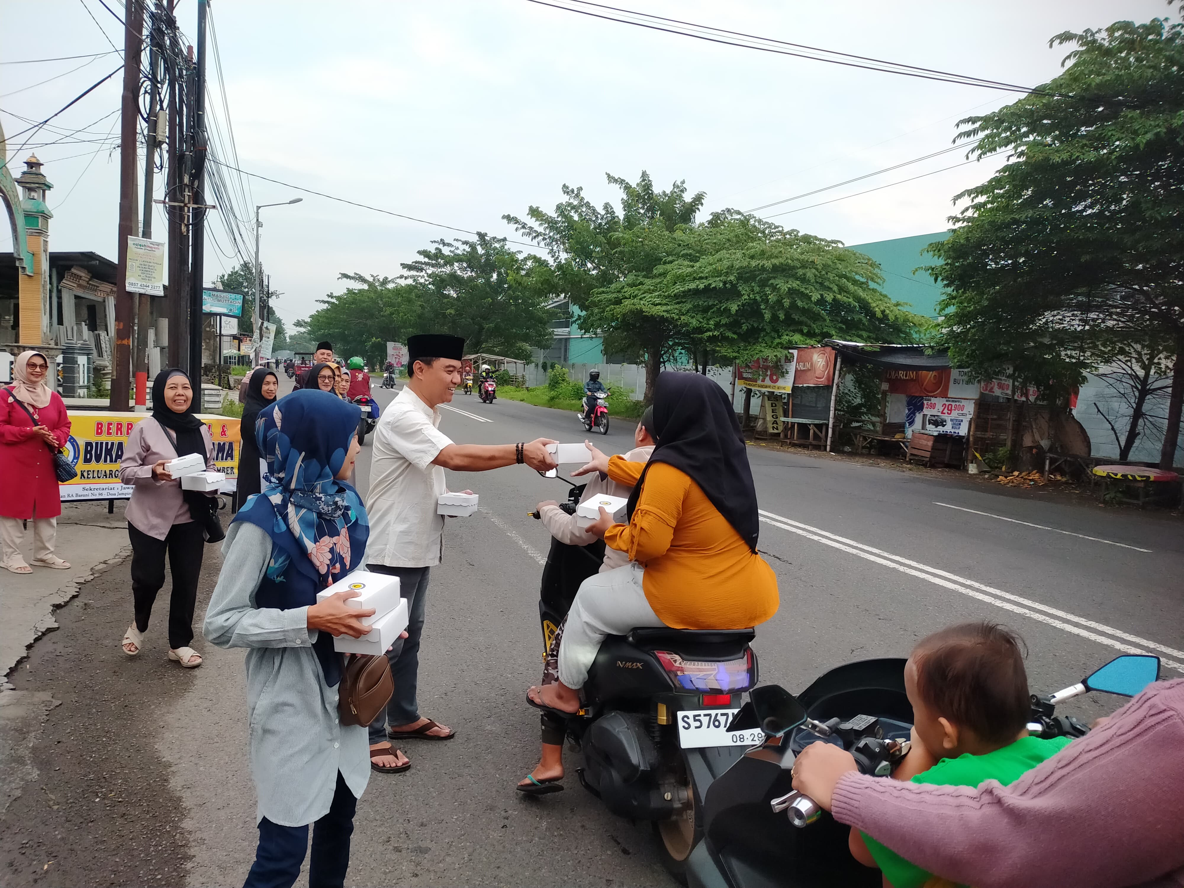 PERERAT SILATURAHMI: Pengurus dan anggota KAUJE Korda Mojokerto Raya membagikan takjil pada pengguna jalan yang melintas di depan Kantor Jawa Pos Radar Mojokerto, Sabtu (8/3) petang.