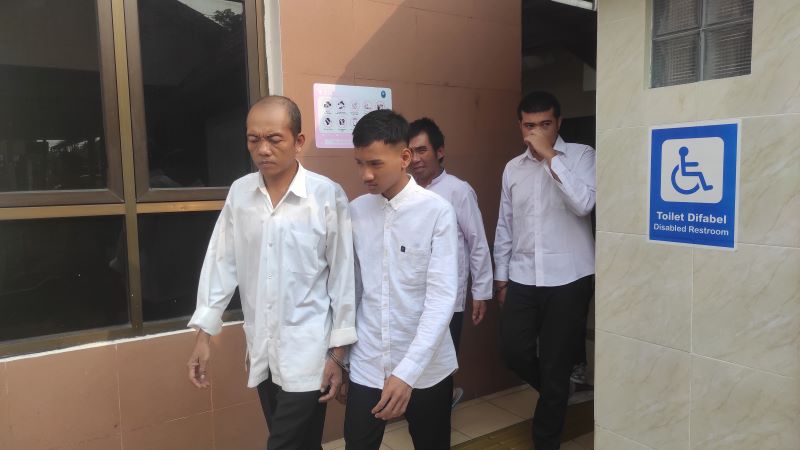 TEGA: NH, dikeler petugas menuju mobil tahanan usai menjalani sidang di Pengadilan Negeri Mojokerto, kemarin.