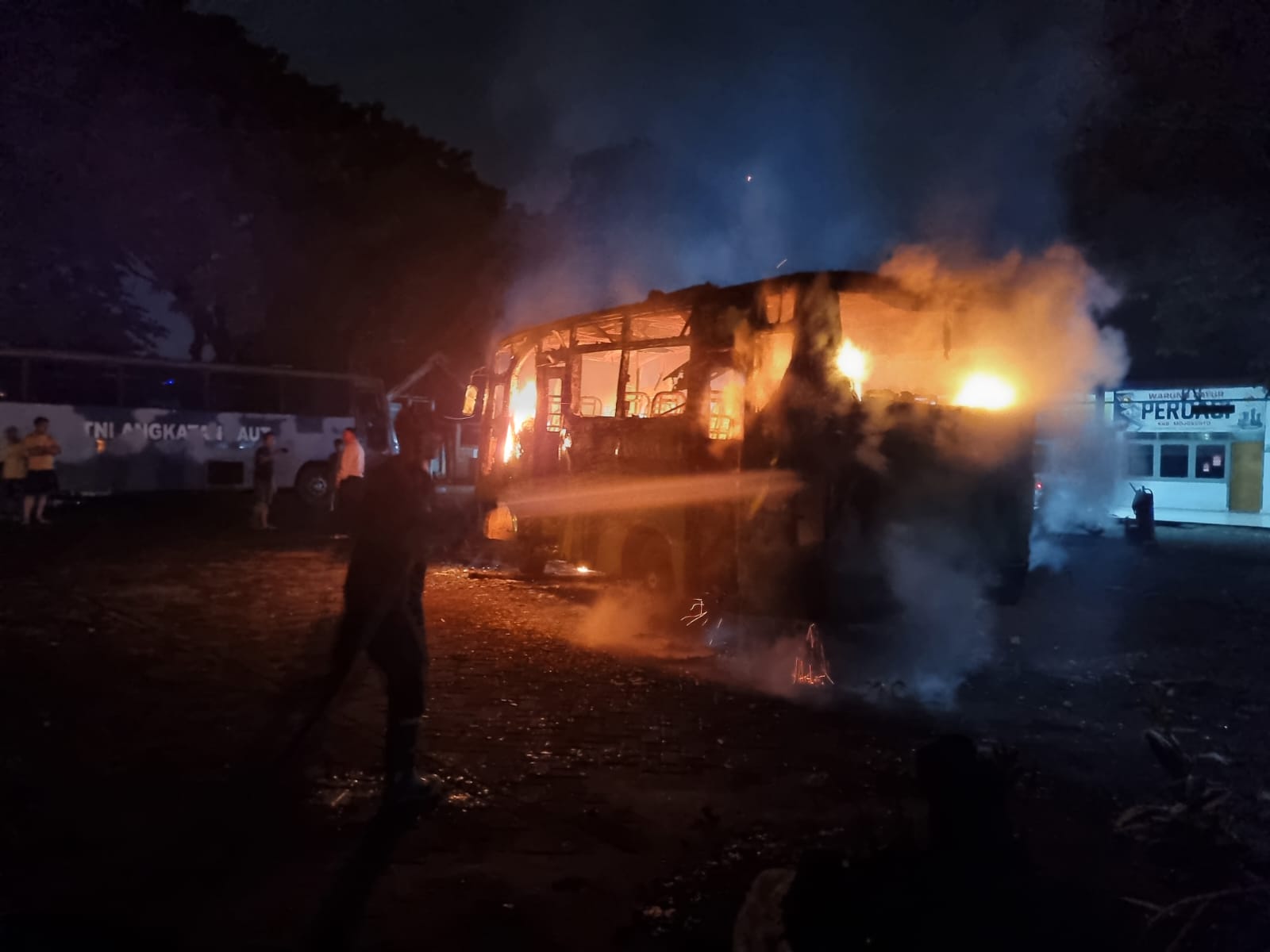 HANGUS: Petugas damkar memadamkan kebakaran bus di Terminal Kertajaya, Kota Mojokerto, Minggu (16/3).