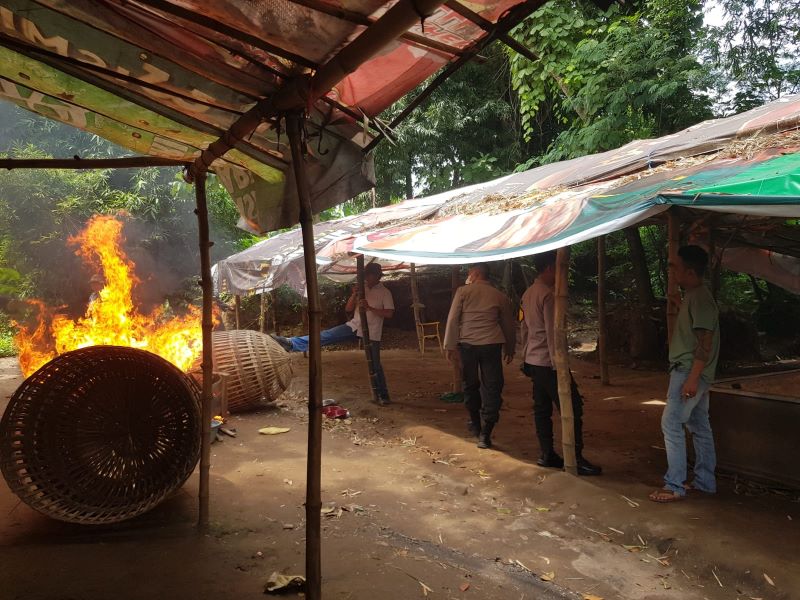 DIMUSNAHKAN: Petugas membakar perlengkapan dan arena judi sabung ayam di Dusun Batok Palung, Desa Temon, Kecamatan Trowulan.