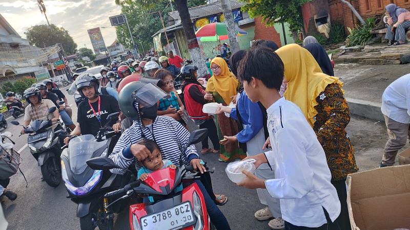 ANTUSIASME: Kepala SMPN 8 Mojokerto Siti Nuryati dan para siswa membagikan ratusan paket takjil kepada pengguna jalan, kemarin (20/3).