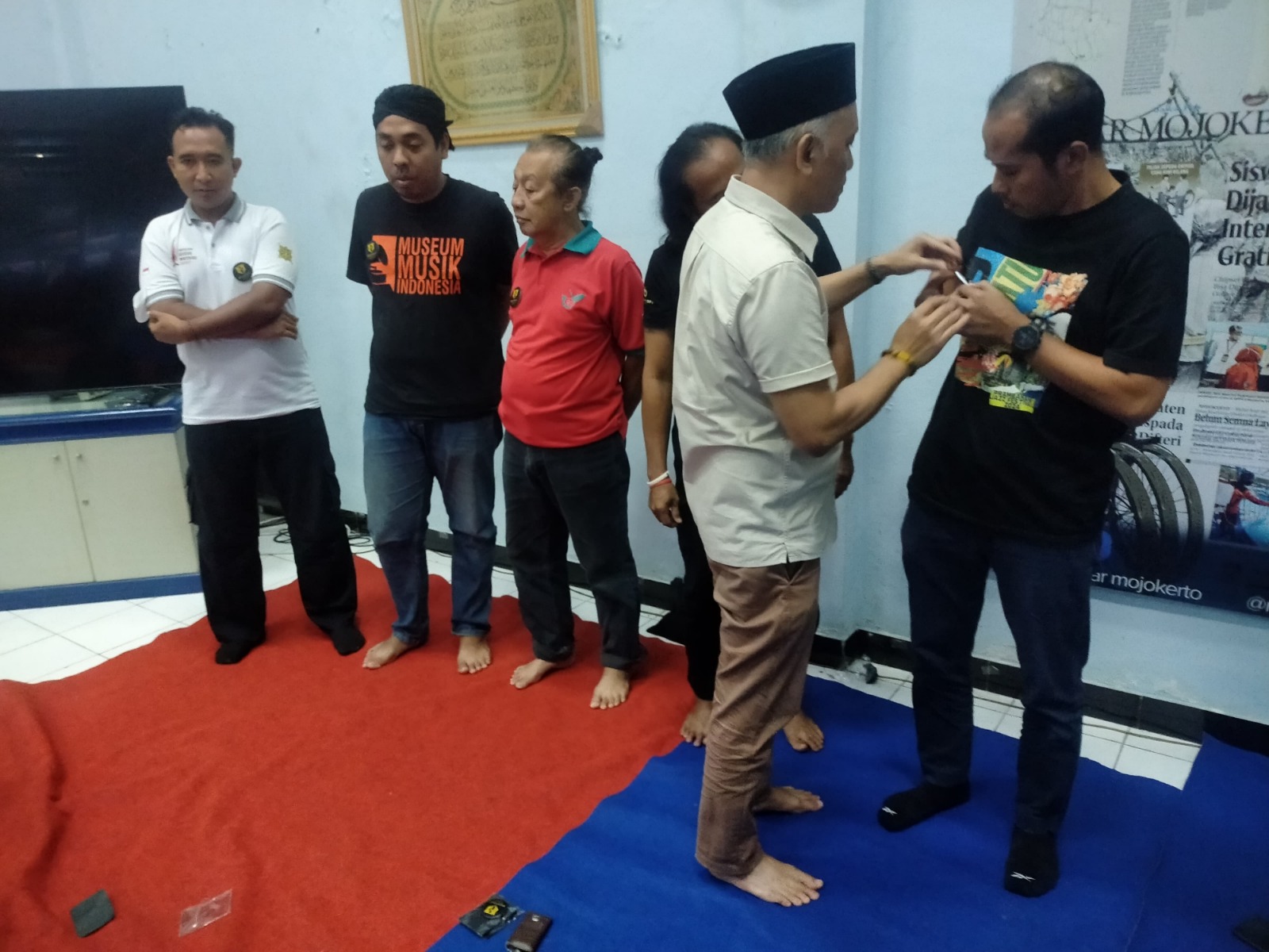 KOMITMEN: Anggota KAUJE sekaligus inisiator MTB, Solikin, menyematkan pin gerakan wisata Majapahit pada sejumlah pegiat wisata di kantor Jawa Pos Radar Mojokerto, Sabtu (22/3).