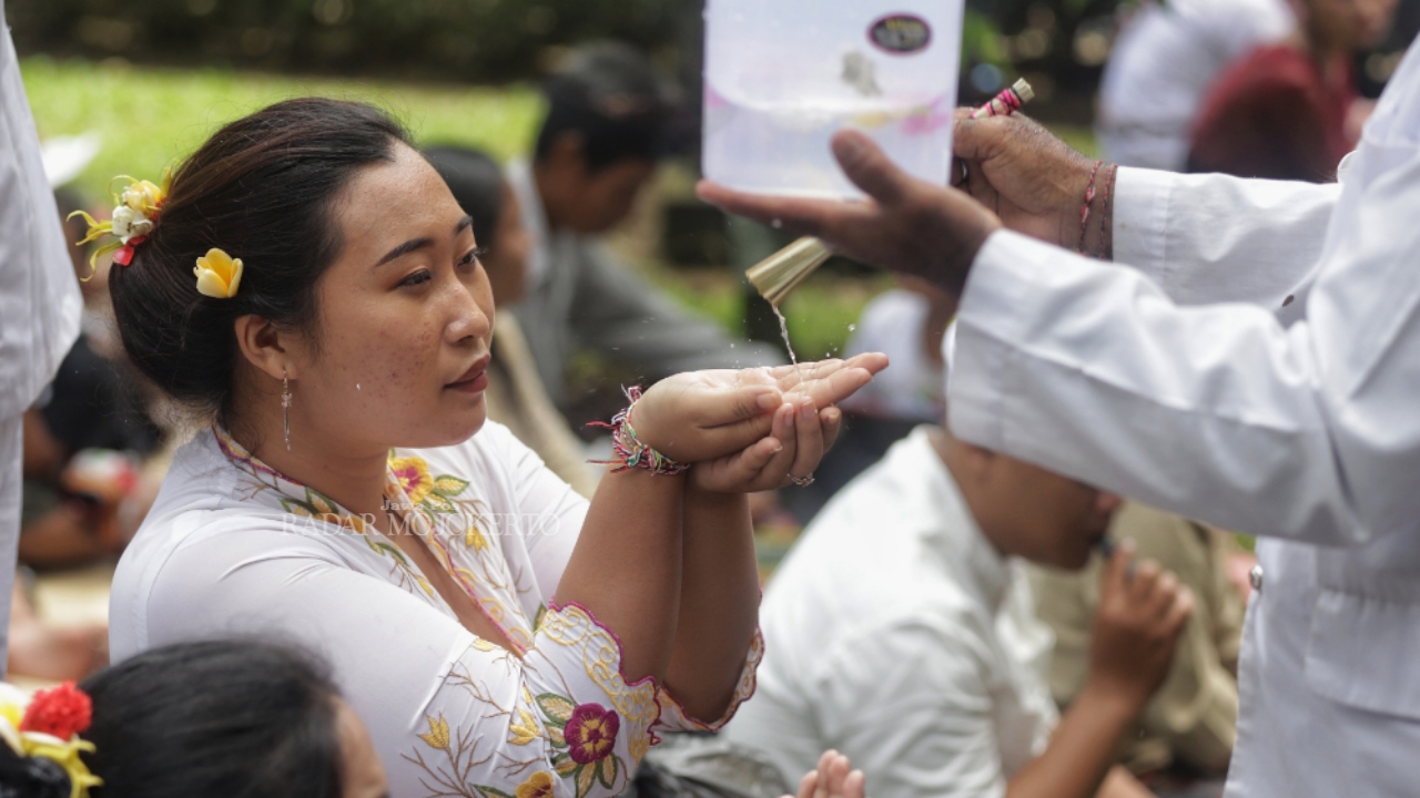 MELASTI: Seorang umat Hindu mendapat air suci ketika mengikuti upacara Melasti di Patirtaan Jolotundo, Kecamatan Trawas, Kabupaten Mojokerto, Minggu (23/3).