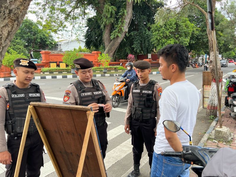 DIPANTAU: Polisi melakukan patroli ke jasa penukaran uang baru di Jalan Ahmad Yani, Kota Mojokerto, kemarin.