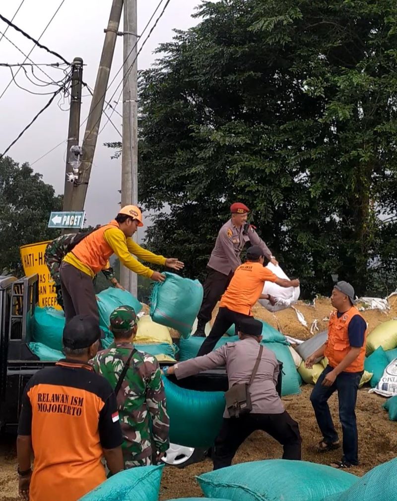 TEKAN FATALITAS: Petugas bersama relawan mempertebal dinding sekam jalur penyelat Tikungan Gotekan di Desa/Kecamatan Pacet, Senin (24/3).