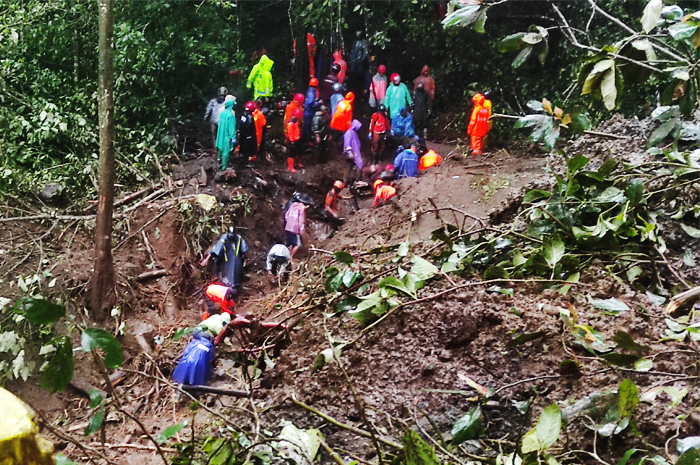 BERJIBAKU: Petugas Basarnas, kepolisian, BPBD Kabupaten Mojokerto, BPBD Kota Batu dan tim relawan berupaya mengevakuasi korban di dalam mobil yang tertimbun material longsor di jurang jalur alternatif
