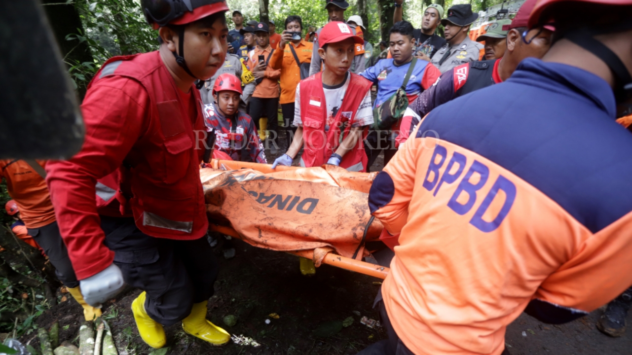 KORBAN LONGSOR: Petugas gabungan dari PMI, Basarnas, kepolisian, dan relawan mengevakuasi korban longsor di jalur Pacet-Cangar, Pacet Kabupaten Mojokerto, Jumat (4/4) pagi.