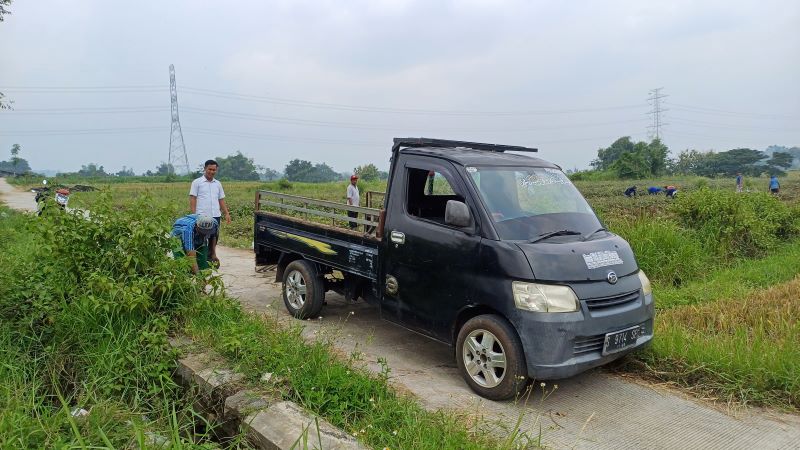 SAPA: Sekretaris Desa Payungrejo, Feridiyanto sedang melihat Jalan Usaha Tani (JUT) di Dusun Bulupayung dan menyapa petani waktu panen.
