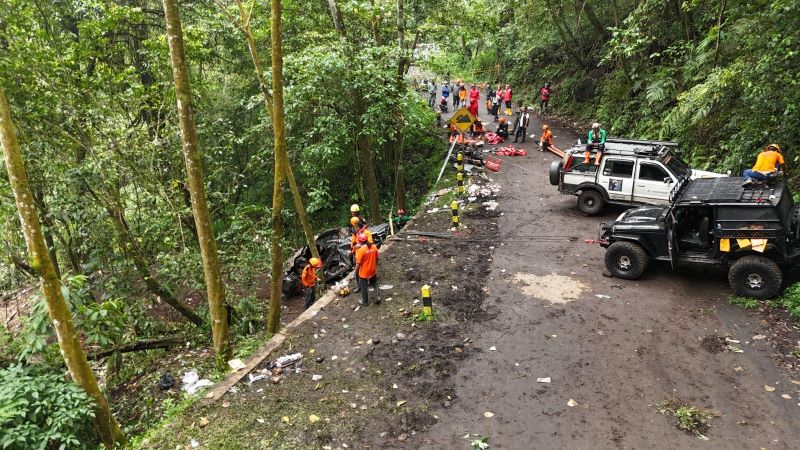 DIKEREK: Petugas gabungan mengevakuasi rangka kendaraan yang terpendam longsoran ke permukaan jalan Pacet-Cangar, Rabu (9/4).