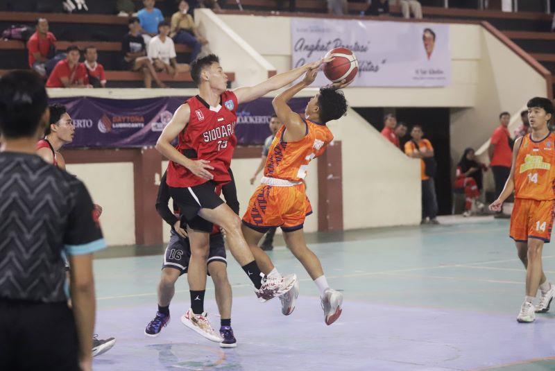 PELAJARAN BERHARGA: Pebasket Porprov Kota Mojokerto (oranye) dihadang dua pemain Porprov Sidoarjo di laga eksbhisi Ramadan League 2025 di GOR Majapahit, Kota Mojokerto, Jumat (21/3).