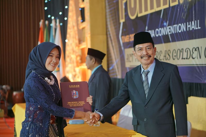 TUNTAS: Kepala SMAN 1 Sooko Sutoyo menyerahkan ijazah secara simbolis dalam kegiatan wisuda siswa tahun ajaran 2023/2024.