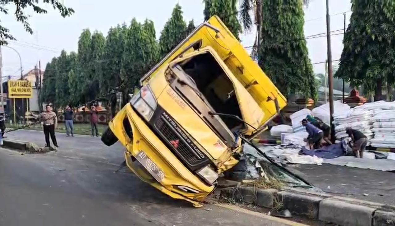PANIK: Truk ekspedisi yang alami kecelakaan dan terguling di depan SPN Polda Jatim, Jalan Raya Bangsal, Kecamatan Bangsal, Kabupaten Mojokerto, berhasil dievakuasi, Selasa (15/4) pagi.&nbsp;