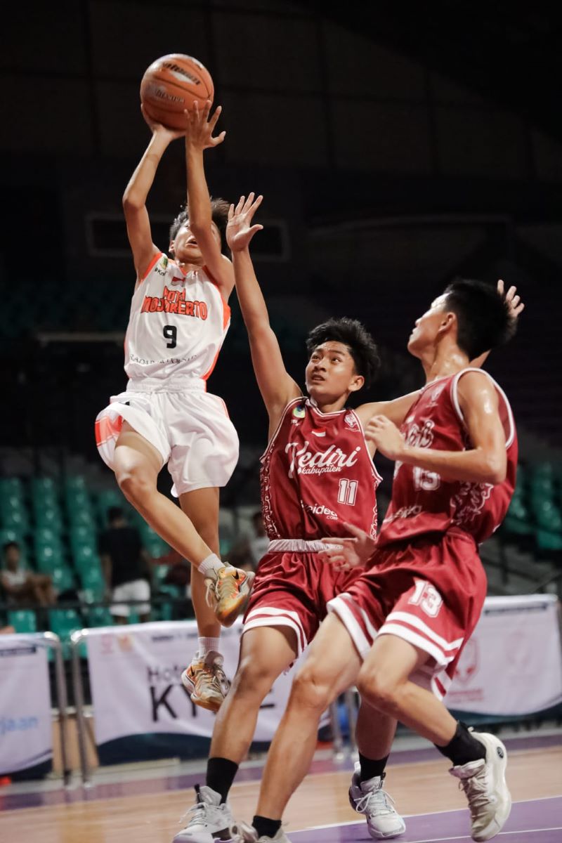 TAK PATAH ARANG: Pebasket putra Kota Mojokerto (putih) berjibaku merebut bola dari kawalan pebasket Kabupaten Kediri (merah) di play off Porprov 2025, Senin (14/4).