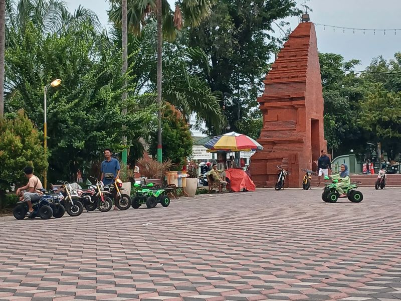 SEMPAT DIRAZIA: Pengunjung menaiki mobil mainan yang disewakan di area Alun-Alun Wiraraja, Kota Mojokerto, Kamis &nbsp;(17/4).