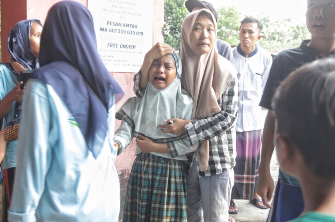 HISTERIS: Warga menenangkan santri yang histeris usai mengetahui kejadian kebakaran di dekatnya.