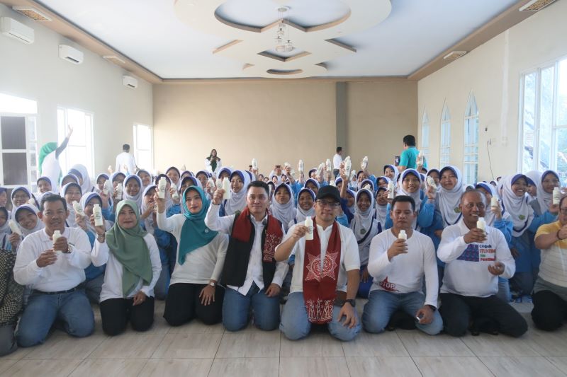 TAMBAHAN GIZI: Bupati Muhammad Albarraa bersama Wabup M. Rizal Oktavian dan Ketua Penggerak PKK Kabupaten Mojokerto Shofiya Hanak Albarra bersama pelajar MTs Salafiyah Syafi&rsquo;iyah Klinterejo.
