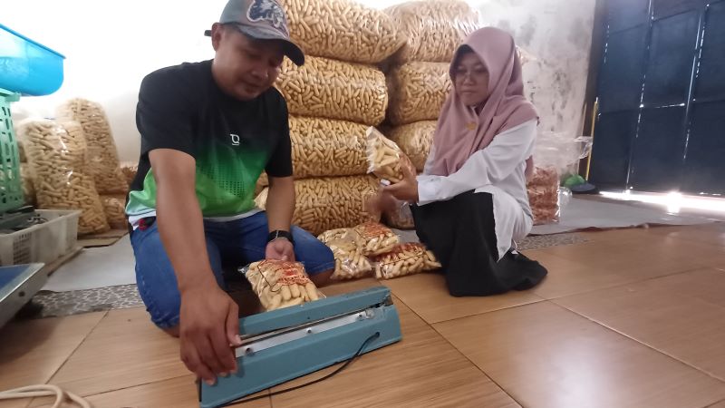 UMKM: Sekretaris Desa Gedangan Ratna Anggraini sedang melihat proses pengepresan Krupuk Tengiri di rumah Iwan Siswanto.