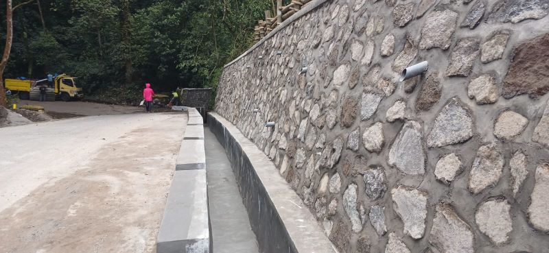 BERPROGRES: Pekerja mengecor bahu Jalan Raya Sumber Brantas di Desa/Kecamatan Pacet yang menjadi titik longsor, kemarin (2/5).