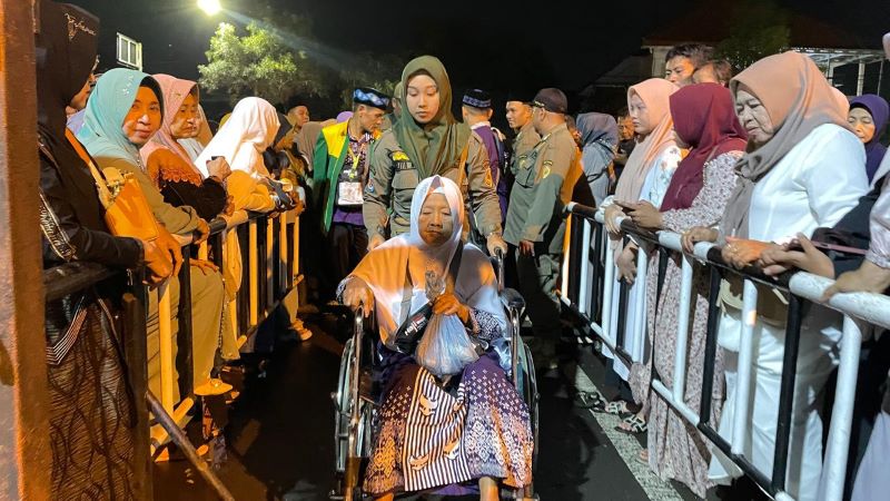 SEMOGA SELALU SEHAT: CJH lansia didorong menggunakan kursi roda menuju bus pengantar sebelum diberangkatkan ke Asrama Haji Sukolilo Surabaya, di halaman Pemkab Mojokerto, Senin (5/5) dini hari.