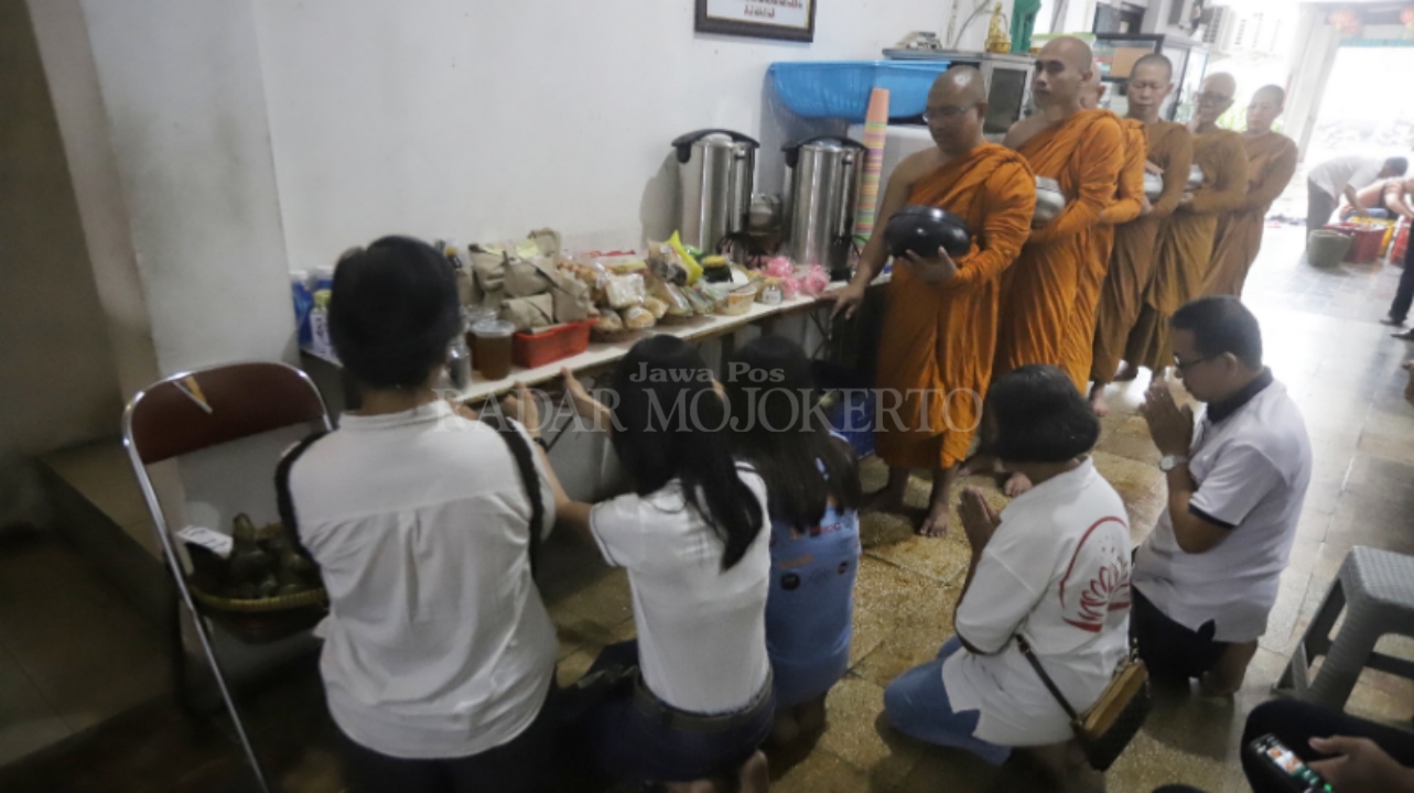 KHIDMAT: Umat Buddha memberikan sedekah kepada Biksu di Kota Mojokerto yang menjalani tradisional pindapata menjelang Hari Raya Waisak, Minggu (11/5).
