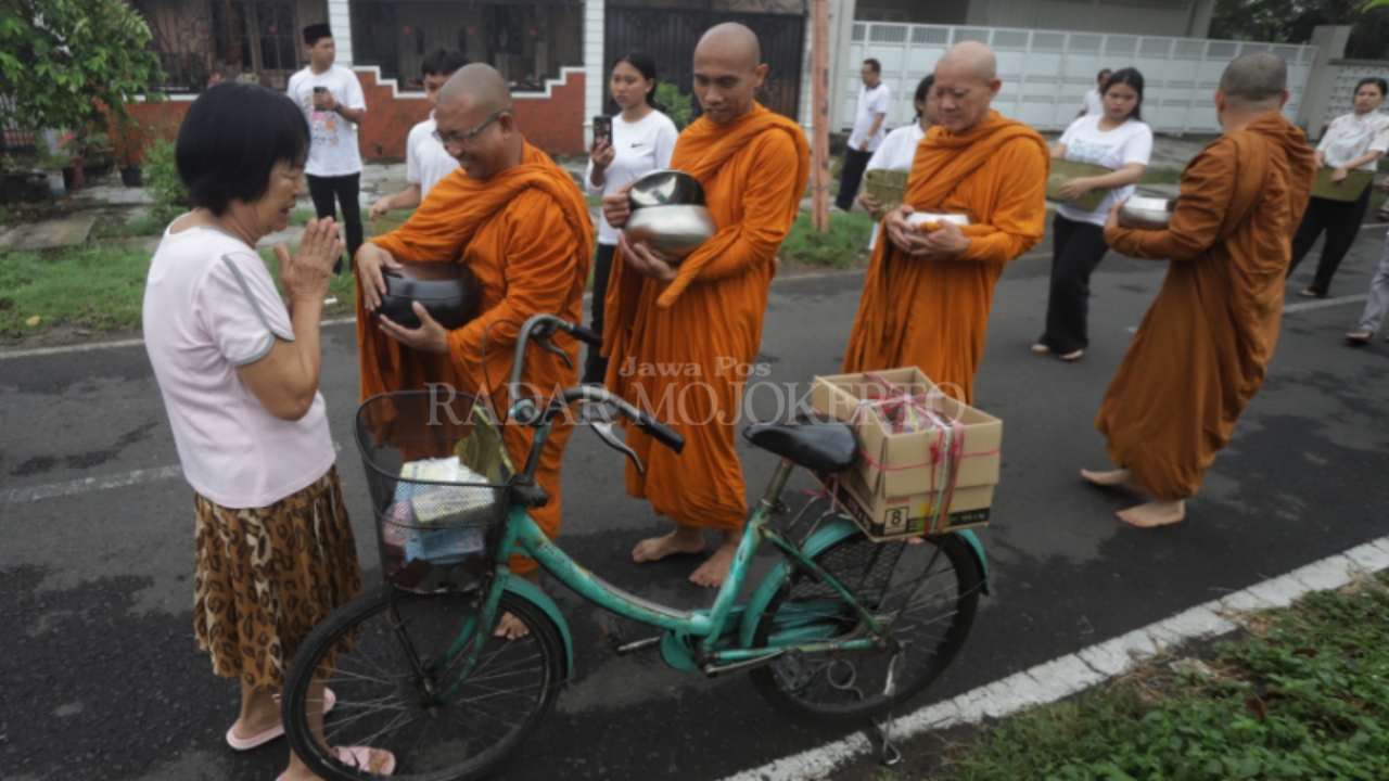JALAN DHARMA: Umat memberi sedekah kepada biksu yang menjalani pindapata di Kecamatan Magersari, Kota Mojokerto, Minggu (11/5).