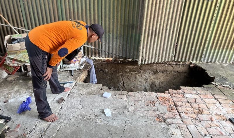 BERLUBANG: Petugas BPBD Kabupaten Mojokerto memeriksa kondisi rumah warga yang ambrol tergerus sungai di Desa Mojojajar, Kecamatan Kemlagi, kemarin (12/5).