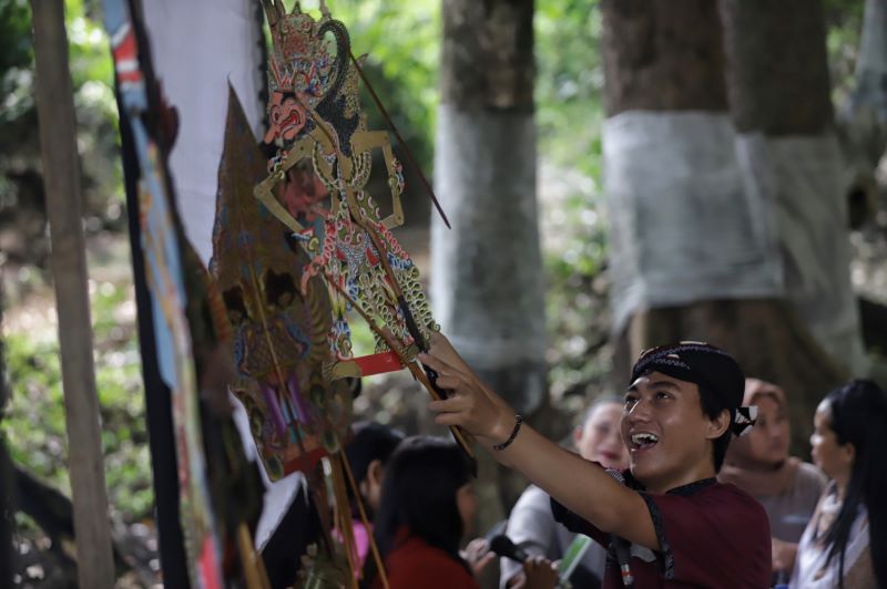 RITUAL WAYANGAN: Dalang Ki Erwan memainkan wayang kulit ketika wayangan di pepunden Dusun Sekiping, Desa/Kecamatan Dawarblandong, Kabupaten Mojokerto, (14/5).