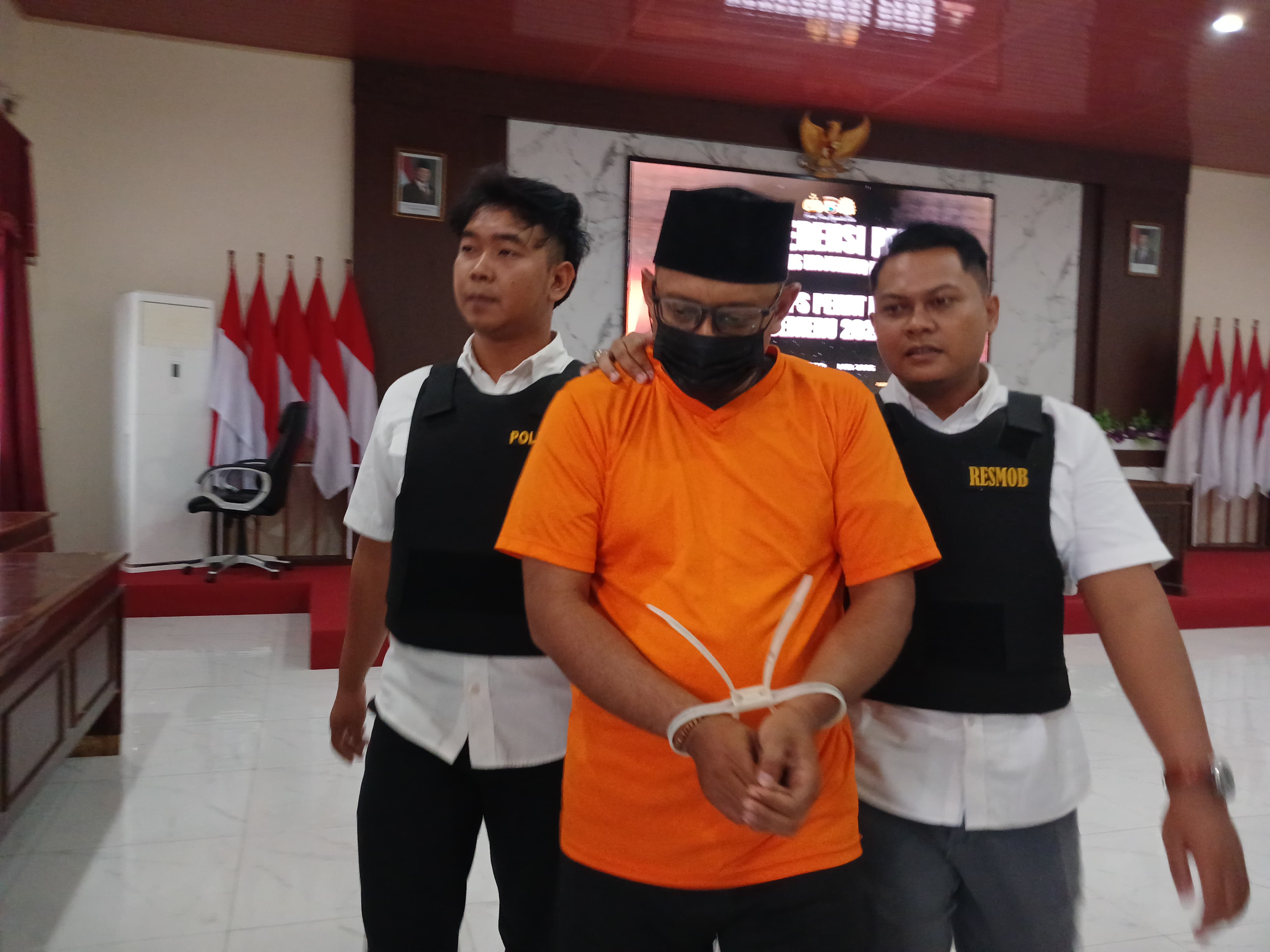 DITAHAN: Tersangka Bagus Lukita Adhi dikeler petugas di Mapolres Mojokerto Kota, Rabu (14/5).
