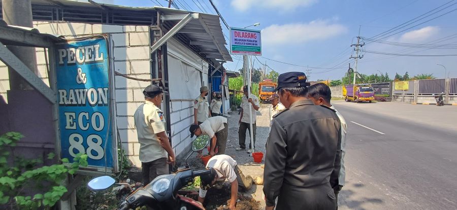 PICU KERESAHAN: Petugas Satpol PP Kabupaten Mojokerto bersama Forkopimca Kemlagi dan perangkat Desa Japanan, memasang plang di depan warung remang-remang, Rabu (7/5).