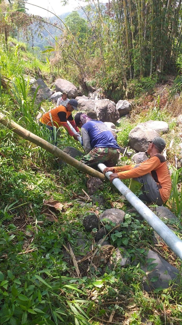 HIDUP SEHAT: Pekerja memasang dan menyambung saluran pipa air bersih dari sumber mata air untuk kebutuhan air minum dan sanitasi masyarakat Desa Tamiajeng, Kecamatan Trawas.