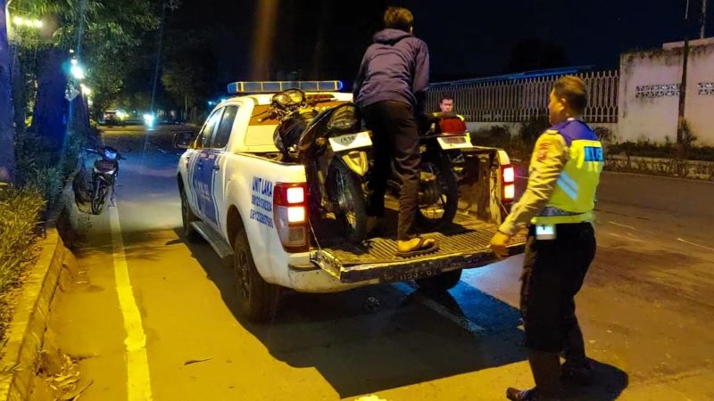 BARANG BUKTI: Petugas Unit Gakkum Satlantas Polres Mojokerto mengevakuasi motor yang terlibat kecelakaan di Jalan Pemuda, Desa Seduri, Kecamatan Mojosari, Minggu (25/5).