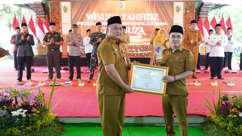KOMITMEN: Kepala Dinas Pendidikan Kabupaten Mojokerto Ludfi Ariyono menyerahkan penghargaan kepada Bupati Muhammad Albarraa atas keberhasilan Capaian Indeks SPM Terbaik Peringkat 1 Nasional.