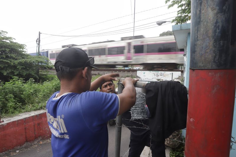 DITUTUP: Petugas memasang pagar kawat berduri di sekitar underpass rel KA, kawasan Benpas, Kota Mojokerto, kemarin (28/5).