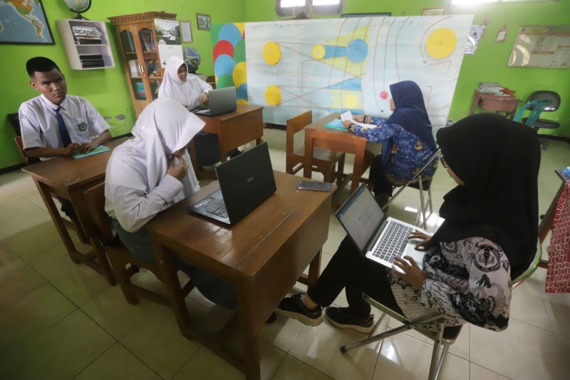 DIDAMPINGI: Siswa SLB PKK Gedeg menjalani ujian didampingi guru.