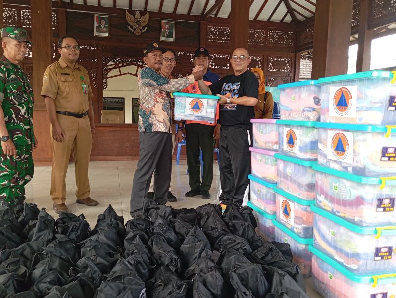 PENANGANAN DARURAT: Kepala Pelaksana BPBD Kabupaten Mojokerto Yo&rsquo;ie Afrida Soesetyo Djati menyerahkan paket sembako kepada warga terdampak secara simbolis di empat desa Kecamatan Dawarblandong.