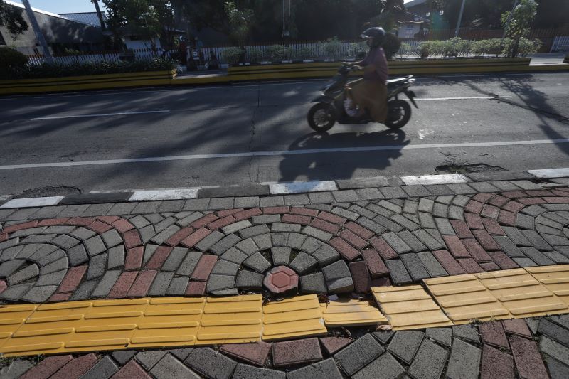 DISAYANGKAN WARGA: Kondisi trotoar Jalan Empunala di sudut simpang empat Sekarputih, Kecamatan Magersari, Kota Mojokerto, yang mengalami jebol, kemarin (12/6).