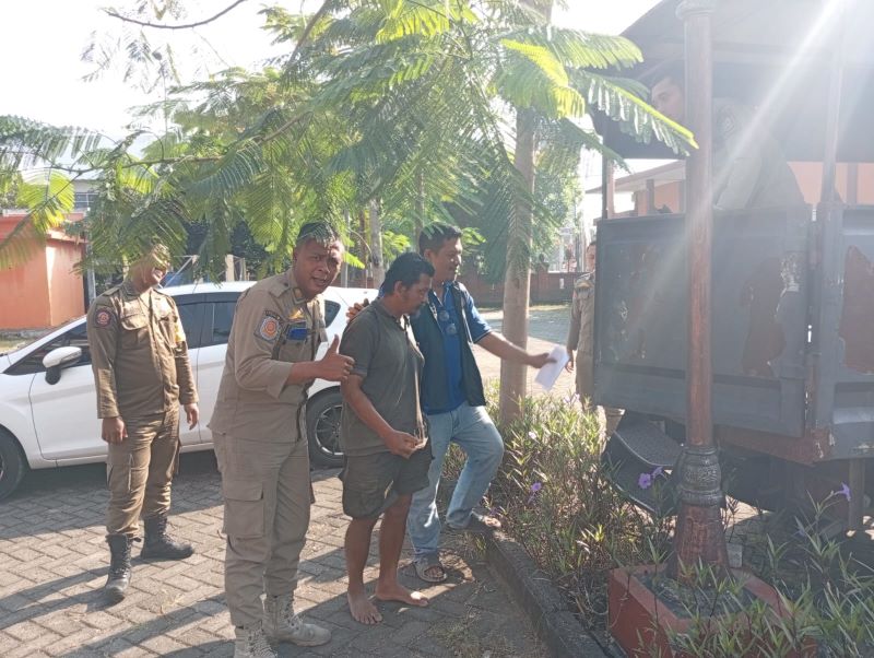 BIKIN KISRUH: Petugas menangkap Lestari Widodo, ODGJ yang menghajar pemilik salon di Jalan HOS Cokroaminoto, Kota Mojokerto, kemarin (23/6).